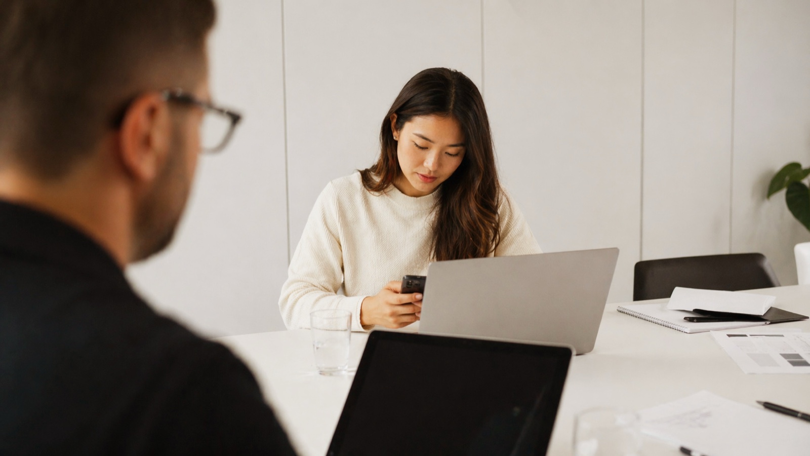 Professional reviewing a smartphone workflow in an office setting
