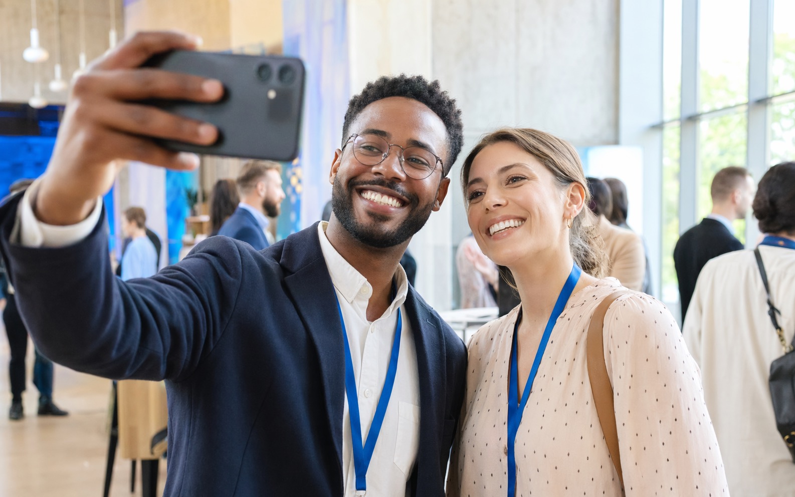 Two professionals taking a quick selfie after meeting at an event